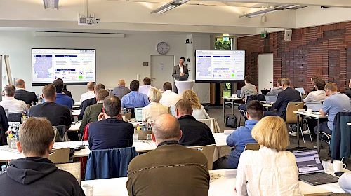 Teilnehmende mit Referenten in einer Fachtagung zum Thema Informationssicherheit